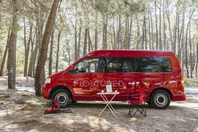 Camper van parked in a camping spot in the forest. Van life concept. — Stock Photo