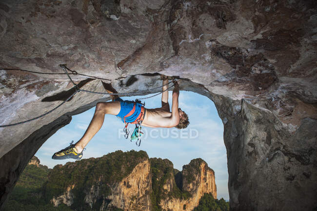 Young man climbing overhanging rock face at Tonsai beach — Stock Photo
