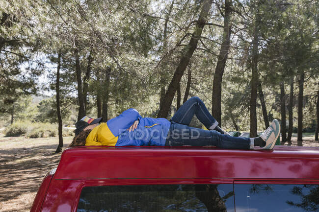 Voyageur homme détendu et prendre une pause tout en étant couché sur le toit d'un v — Photo de stock