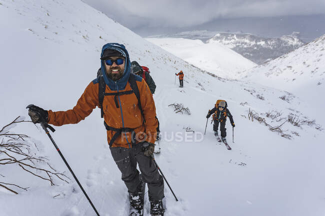 Pessoas com pólos de esqui dividindo-se em montanhas cobertas de neve durante as férias — Fotografia de Stock