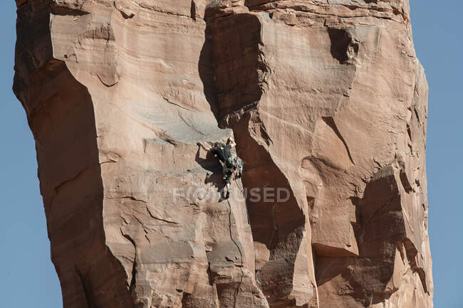 Visão traseira do homem escalando a formação de rochas no Parque Nacional de Canyonlands — Fotografia de Stock