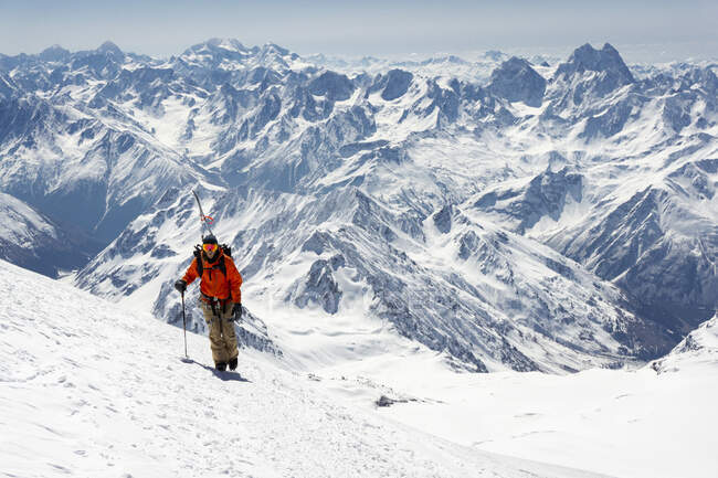 Uomo con palo da sci arrampicata montagna innevata durante le vacanze — Foto stock