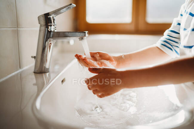 Manos con jabón en el baño, concepto de higiene - foto de stock
