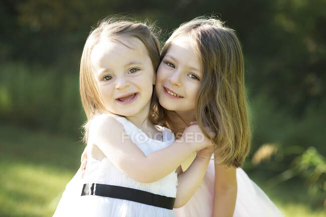 Zwei fröhliche süße kleine Mädchen in Osterkleidern im Freien. — Stockfoto