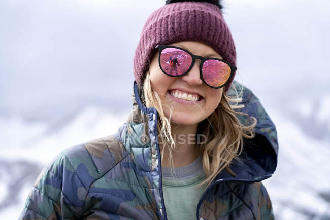 Крупный план портрета улыбающейся молодой женщины в теплой одежде, наслаждающейся отпуском — стоковое фото