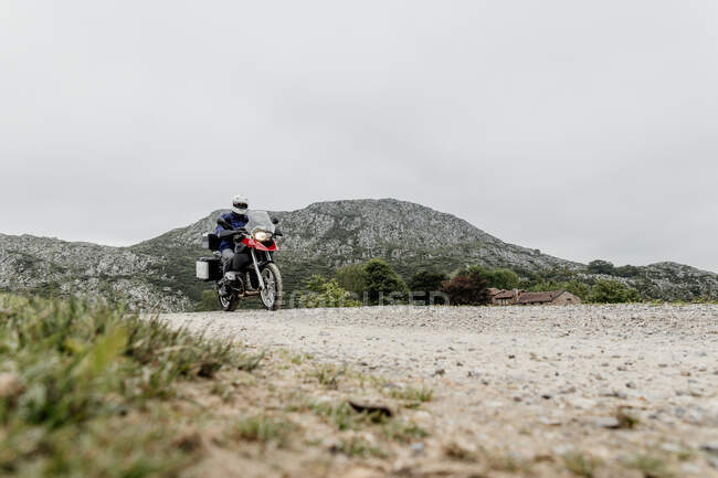 Uomo guida moto in montagna. — Foto stock