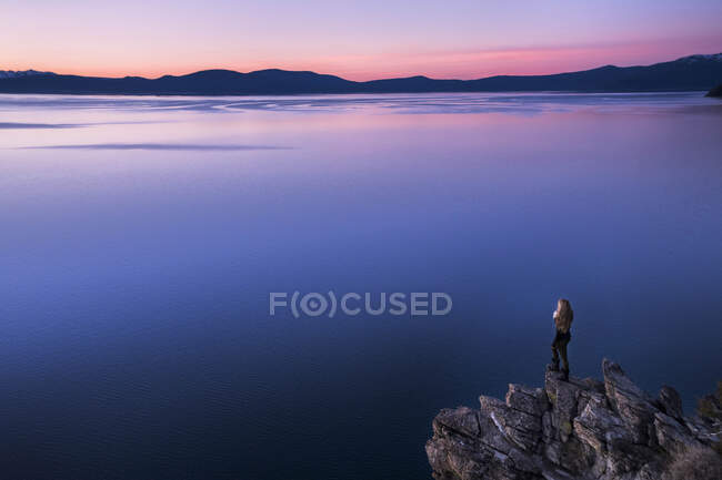 Young female overlooking lake tahoe at sunset — Stock Photo
