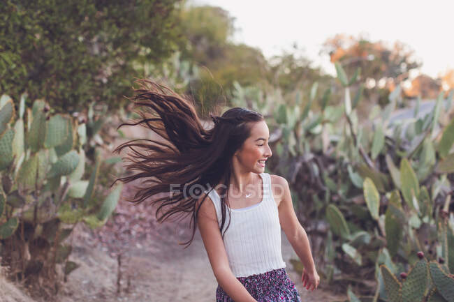 Дівчина змішаної раси, що йде траєкторією кактуса з її довгим волоссям літає . — стокове фото