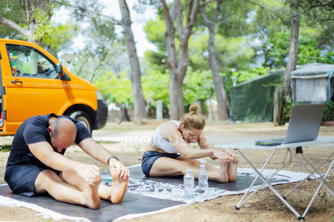 Couple learning yoga online outside — Stock Photo