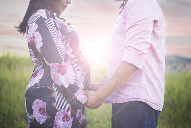 Couple expecting a baby. A man and a woman hold stomachs. — Stock Photo