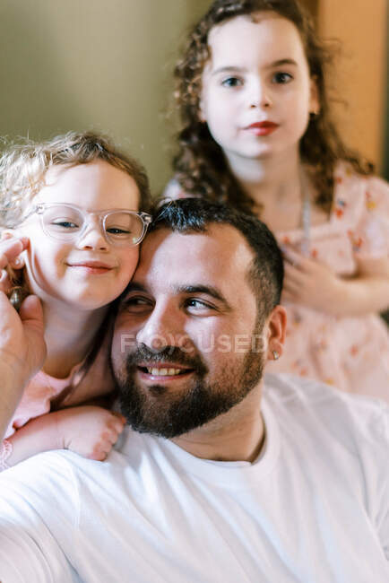 A father spending time with his daughters as they sit together — Stock Photo