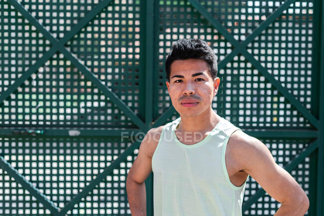 Портрет латиноамериканского спортсмена-мужчины на зеленом фоне. Концепция запуска. — стоковое фото