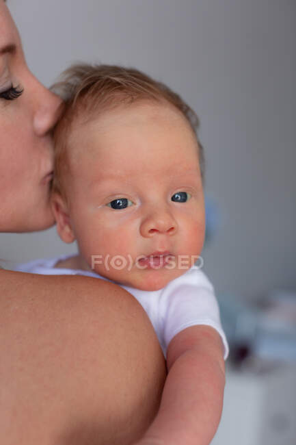 Mom kisses a little newborn baby. Child close-up — Stock Photo