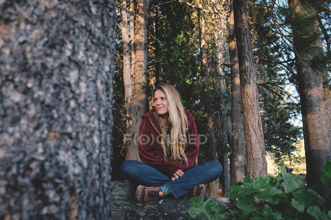 Mulher loira senta-se em paz no meio de uma floresta — Fotografia de Stock