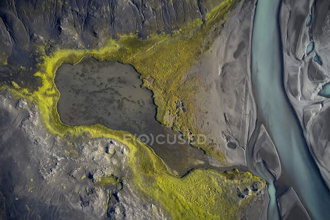 Вид сверху на чистый ручей, протекающий по болотистой местности, покрытой плесенью — стоковое фото
