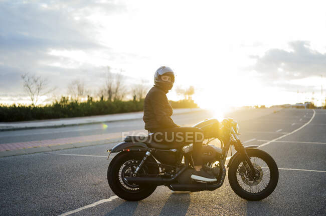Silhouette of man with motorcycle on the street — Stock Photo