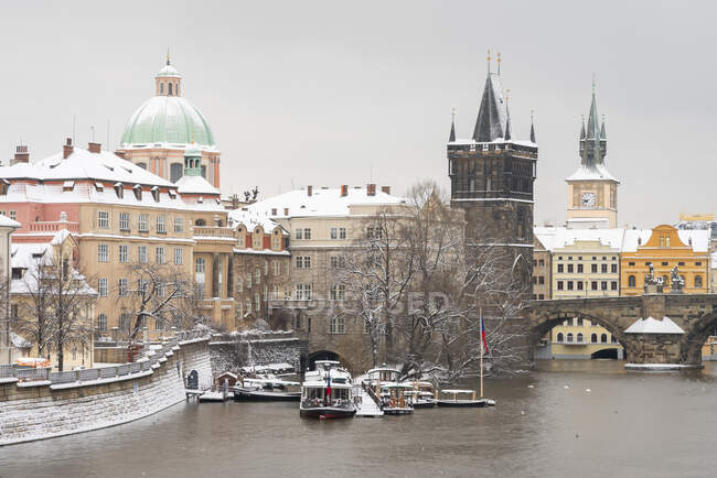 Torre del Puente de la Ciudad Vieja e Iglesia de San Francisco de Asís en invierno, Praga, República Checa - foto de stock