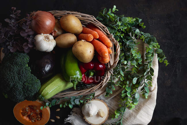 Weidenkorb voller Gemüse mit einem Stück Kürbis als Protag — Stockfoto