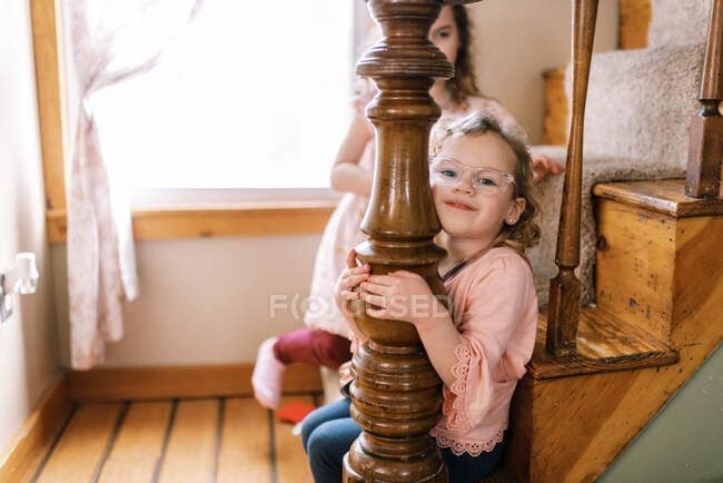 Happy little girl with prescription eye glasses sitting on stairs — Stock Photo