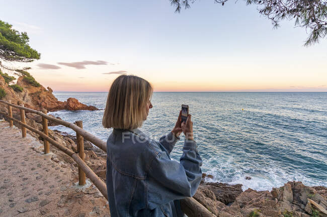 Jovem mulher tirando foto na praia — Fotografia de Stock