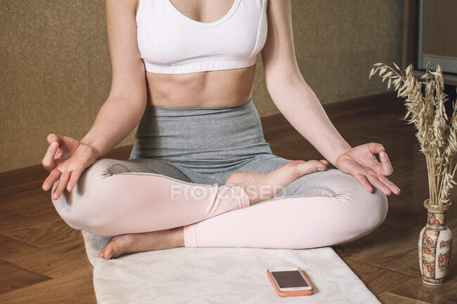 Baixa seção de mulher fazendo meditação em casa — Fotografia de Stock