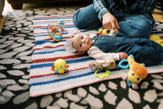 Um bebezinho segurando o dedo de seu pai na mão durante a brincadeira — Fotografia de Stock