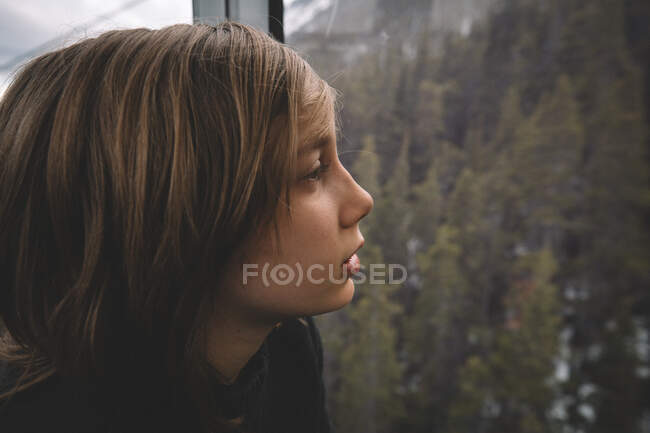 Portrait of a woman looking out of an iron door, on a cloudy day — Stock Photo