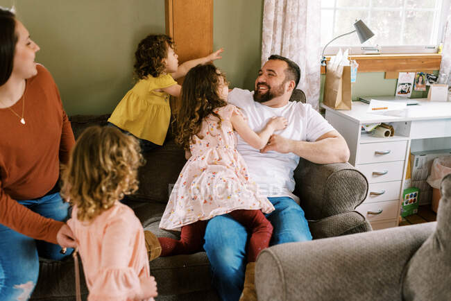 Щаслива велика сім'я лоскоче і сміється разом на дивані у вітальні. — стокове фото
