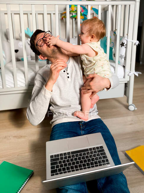 Mann spielt mit seiner Tochter und arbeitet zu Hause an Selbstzerstörung — Stockfoto