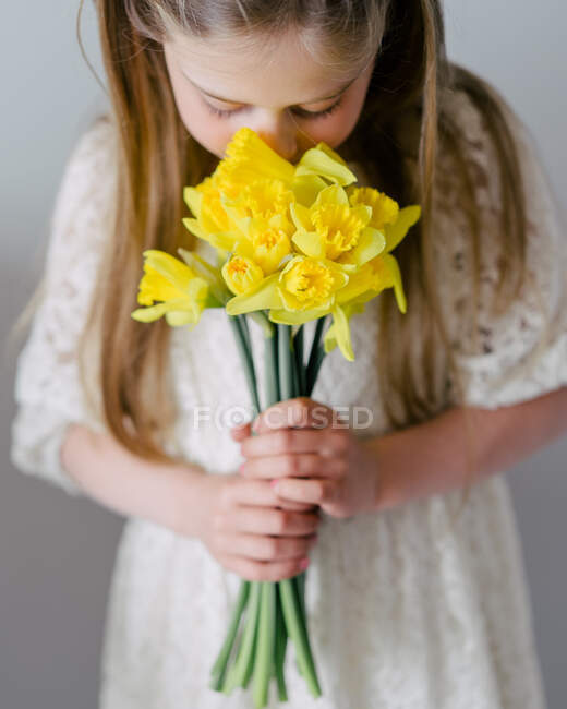 Schönes kleines Mädchen mit einem Strauß gelber Tulpen — Stockfoto