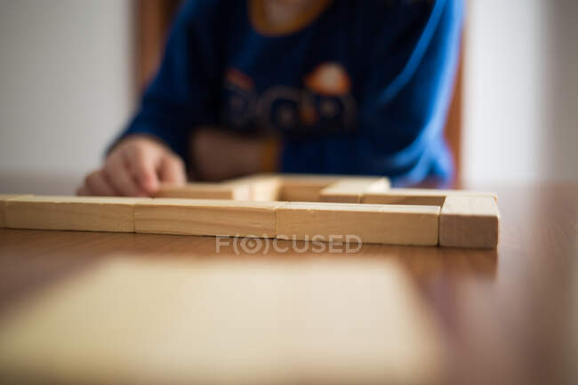 Bambino che gioca con edifici in legno — Foto stock