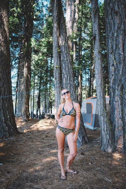 Mujer con Cheetah Bikini Poses para una foto Mientras acampa - foto de stock