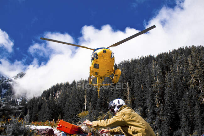 Um helicóptero prepara-se para aterrar e apanhar trabalhadores num local remoto. — Fotografia de Stock
