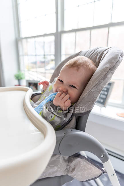 Happy baby boy sitting in high chair. — Stock Photo