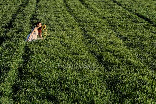Jeune femme posant dans le champ vert — Photo de stock