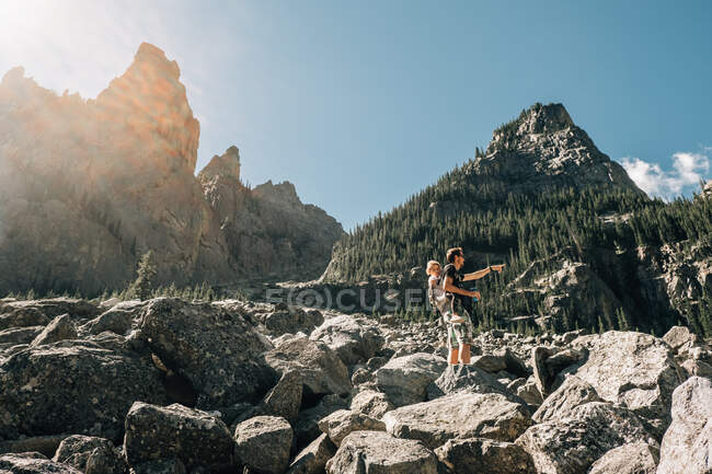 Father hiking with his young daughter in a carrier — Stock Photo