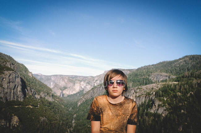 Ragazzo in occhiali da sole posa con Yosemite Valley sullo sfondo — Foto stock
