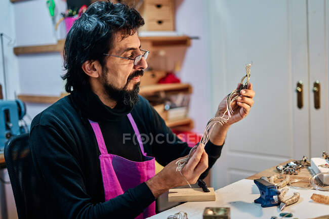 Jeweler craftsman looking and working on jewel at work table — Stock Photo