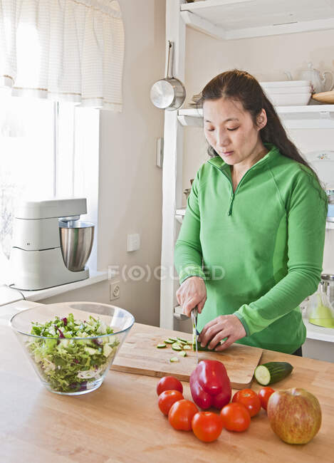 Жінка рубає овочі на кухні ісландського будинку. — стокове фото