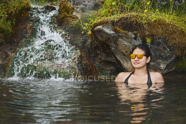 Mujer en la piscina cerca del río, el concepto de las vacaciones. - foto de stock