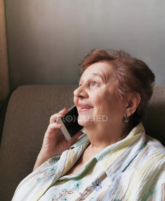Femme âgée parlant sur un téléphone portable souriant joyeusement — Photo de stock