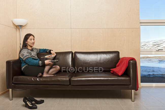 Woman sitting on leather sofa inside of chalet in Iceland — Stock Photo