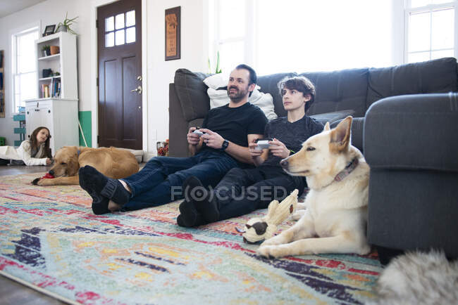 Vater und Zwillingssohn spielen gemeinsam Videospiele. — Stockfoto