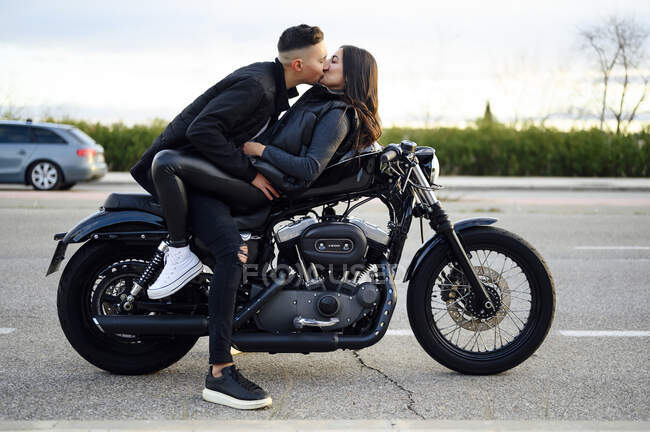 Young couple kissing on the motorbike — young adult, love - Stock Photo |  #470170992