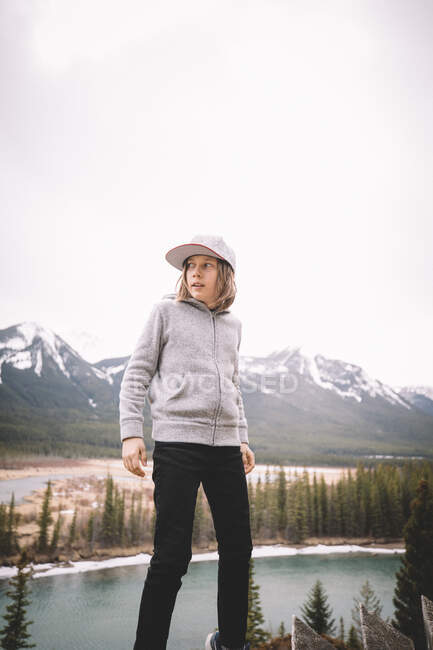 Женщина, стоящая с рюкзаком на холодном утреннем пейзаже. красивая молодая девушка совершает поход в горы — стоковое фото