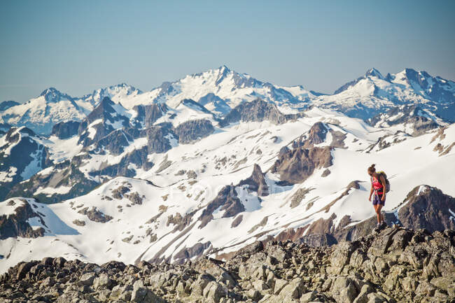 Jovem atraente mochileiro caminhadas sobre terreno rochoso com vista panorâmica — Fotografia de Stock