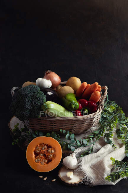 Panier en osier plein de légumes avec un morceau de citrouille comme protag — Photo de stock