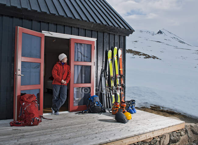 Mujer preparándose para esquiar en casa de campo en Islandia - foto de stock