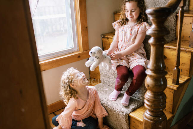 Счастливые маленькие девочки играют вместе на лестнице — стоковое фото