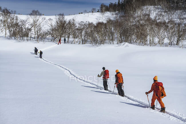 Люди з лижними полюсами розбиваються на сніговому полі під час відпустки — стокове фото